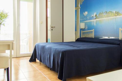 a bedroom with a blue bed with a painting on the wall at Hotel Merano in Grado