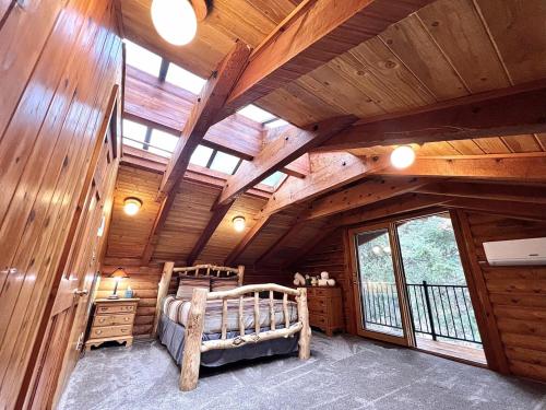 a bedroom in a log cabin with a bed and a window at Log Cabin On The Stream Sundance, Utah in Sundance