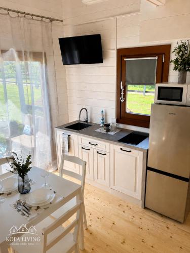 a kitchen with a white refrigerator and a table with a table sidx sidx at KOPA LIVING seaside holiday homes in Nida