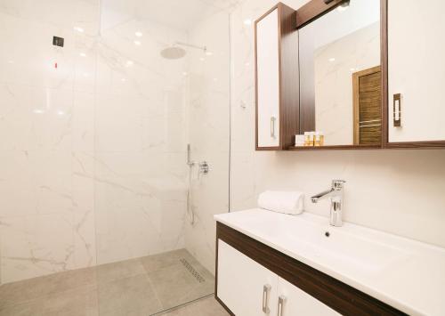 a bathroom with a sink and a shower at Velmare Inn in Ulcinj