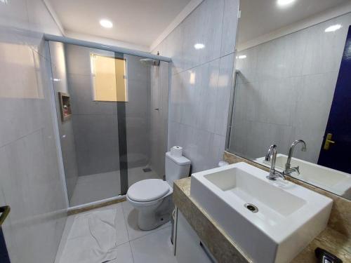 a bathroom with a sink and a shower and a toilet at Anexo da Paz Tucuns Búzios in Búzios