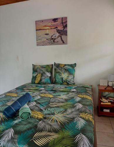 a bed with a colorful comforter and pillows at Le paradis créole in Sainte-Luce
