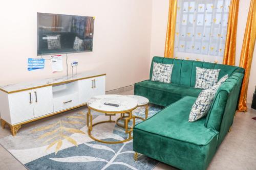 a living room with a green couch and a table at HOBRA HOMEs -Naivasha B in Naivasha