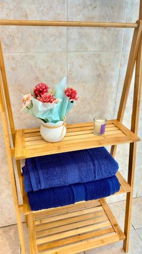 a wooden shelf with flowers and towels on it at Mistura Fina in Sal Rei