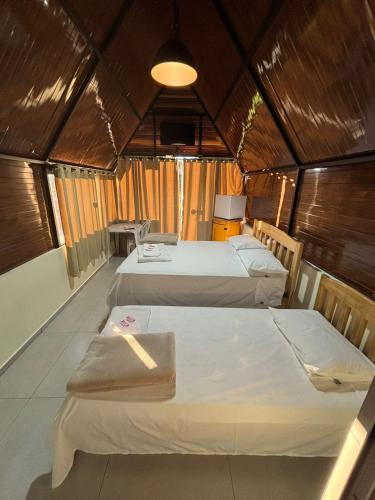 a room with two beds in a small room at RECANTO CANTAGALO Hotel in Cantagalo