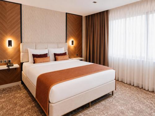 a bedroom with a large white bed and a window at Nevv City Hotel in Istanbul