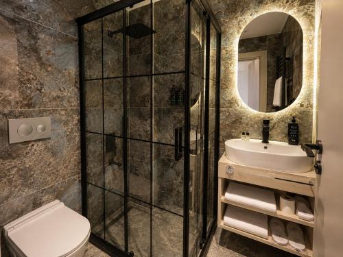 a bathroom with a shower and a toilet and a sink at Nevv City Hotel in Istanbul