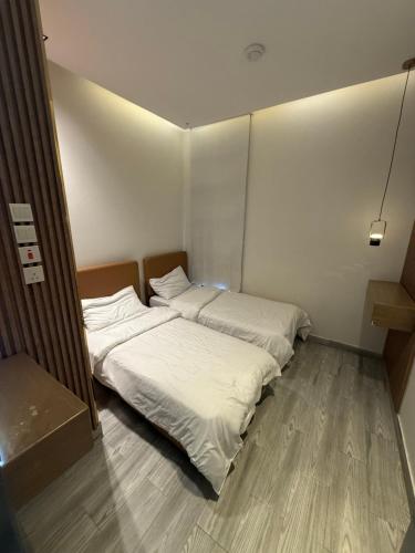 two beds in a small room with white sheets at شاليهات سمو بارك 2 in Taif