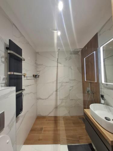 a white bathroom with a sink and a shower at Zlatibor 1 Balkan Square in Zlatibor