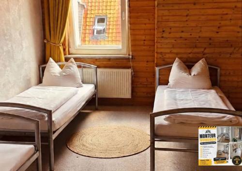 two beds in a small room with a window at Harzer Monteurs-Lounge Domschatz-Nähe in Halberstadt