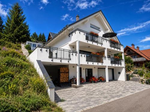 a white house with balconies and a driveway at Villa Number 8 in Feldberg