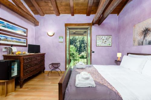 a bedroom with purple walls and a bed and a television at Casa Buonumore in Gaiola