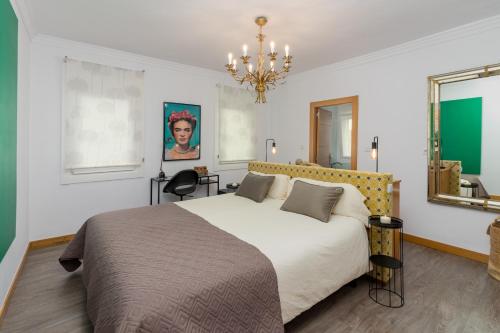 a bedroom with a large bed and a chandelier at La Fuente 33 in Castro-Urdiales