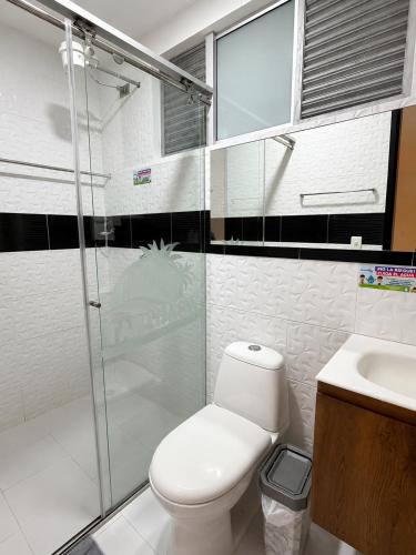 a bathroom with a toilet and a shower and a sink at Hotel Takuara in Vergara