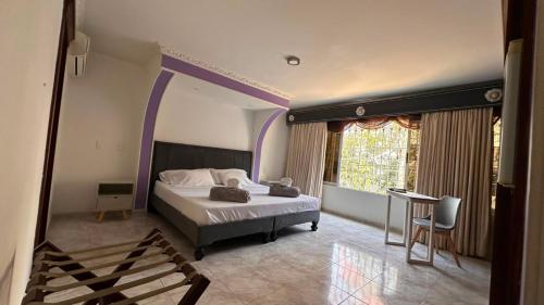 a bedroom with a large bed with a purple trim at Hotel Casa Sharon in Cali