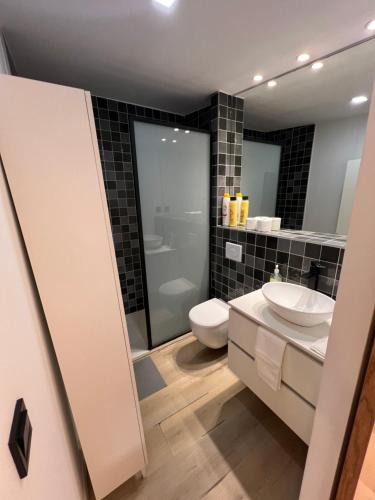 a bathroom with a white toilet and a sink at Serena Boutique Duplex in Madrid