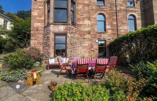a table and chairs in front of a brick building at Lochview at 33a in Gourock