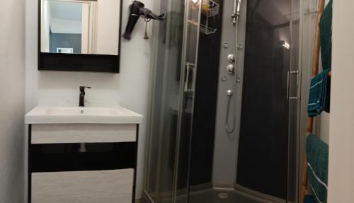a bathroom with a sink and a shower at 36 Baltazia, 2 Ch 2 Pers-Clim jardin terrasse à Sainte-Anne in Sainte-Anne