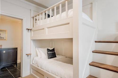 a white bunk bed in a room with a staircase at Hotel Burg in Leesburg