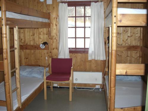 ein Zimmer mit zwei Etagenbetten und einem Stuhl in der Unterkunft IMI Stølen in Oppdal