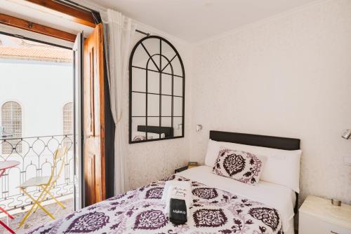 a bedroom with a bed and a balcony at Charme da Graça - Guest House in Lisbon