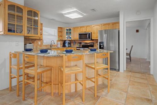 a kitchen with a island with stools and a refrigerator at Manatee Bay in Apollo Beach