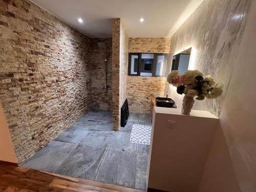 a room with a brick wall and a vase of flowers at Bed and breakfast ALDIANA in Cap Skirring