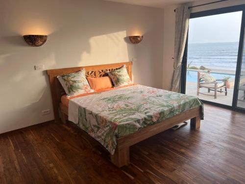 a bedroom with a bed with a view of the ocean at Bed and breakfast ALDIANA in Cap Skirring
