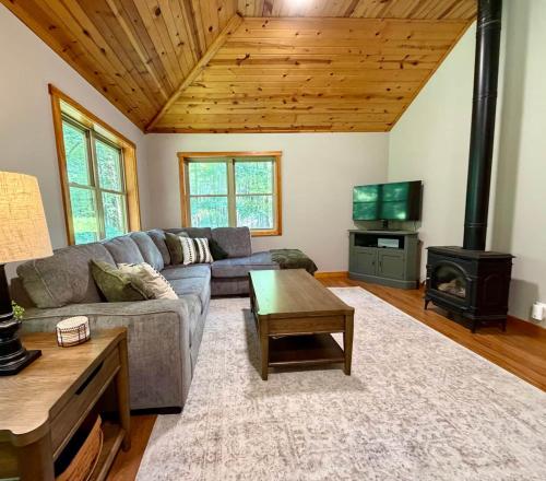 a living room with a couch and a stove at Honey Ridge Forest Retreat in South Bloomingville