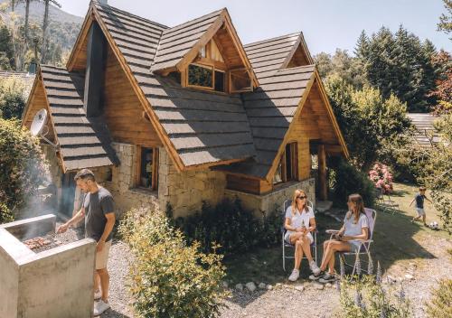 a group of people sitting outside of a house at Tillka - Casas de Montaña in Villa La Angostura