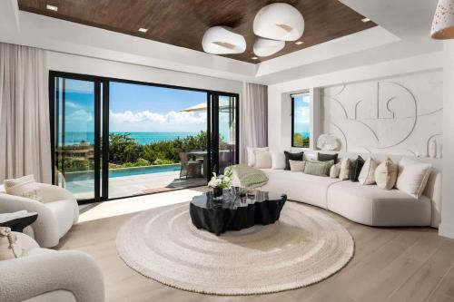 a living room with white furniture and a large window at Villa Angelina in Leeward