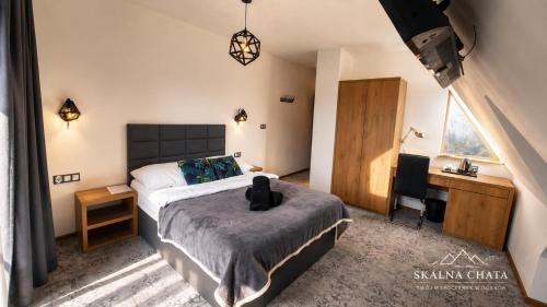 a bedroom with a bed and a desk and a chair at SKALNA CHATA 150 m do Term, Basen in Białka Tatrzańska