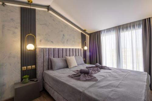 a bedroom with a large bed with purple blankets on it at White Pampas Tiny Houses 1 in Paralia Dionysiou