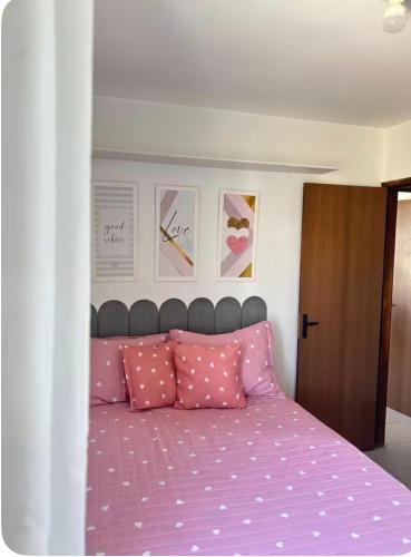 a bedroom with a pink bed with pink pillows at Apto no Janga in Paulista