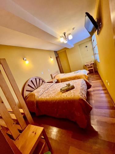 a bedroom with two beds and a tv in it at Hostal Cactus in Cusco