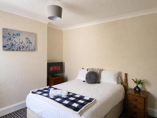 a bedroom with a bed with a checkered blanket on it at 52 - room 3 - smart TV in Swansea