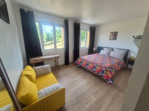 a bedroom with a bed and a couch at L'Aubier in Saint-Maur