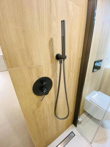 a shower nozzle on a wooden door in a bathroom at Orla Przystań in Gliczarów Górny