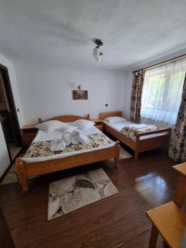 a bedroom with two beds and a window at Cabana Diana&Larisa in Arieşeni