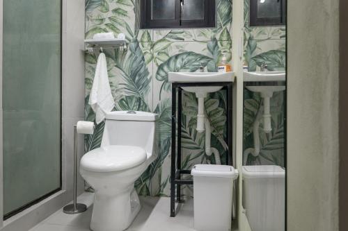 a bathroom with a toilet and two sinks at Cocles Green Studios in Cocles