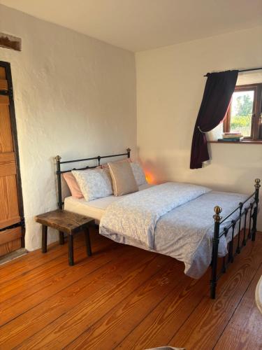 a bedroom with a bed and a wooden floor at THE FARMHOUSE Room 1 in Balcunnin