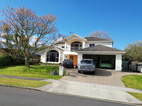 a house with a car parked in a driveway at Makepeace Place Homestay in Hamilton