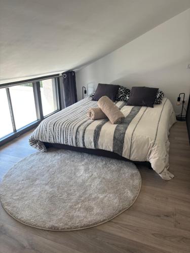 a bed with two pillows and a rug in a bedroom at Appartement avec jacuzzi et piscine sur les remparts in Langres