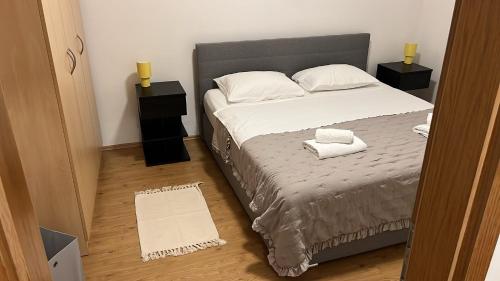 a bedroom with a bed with two pillows on it at Apartments Branimir in Murter