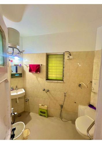 a bathroom with a sink and a toilet and a window at Serene Guest House ll 2 Ac Rooms ll WiFi ll Tv ll Big Garden in Lonavala