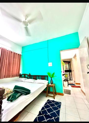 a bedroom with a large bed with a blue wall at Serene Guest House ll 2 Ac Rooms ll WiFi ll Tv ll Big Garden in Lonavala