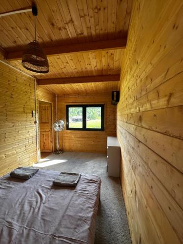 a room with two beds in a wooden cabin at Srebrny Domek in Ostroszowice