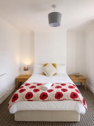 a bedroom with a bed with red flowers on it at 52 - room 4 - city view in Swansea