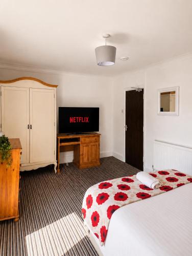 a hotel room with a bed and a flat screen tv at 52 - room 4 - city view in Swansea