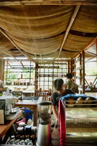 a couple of people in a kitchen preparing food at Happy Lemon Tree lodge in Sauraha